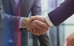 夕暮れの都市ビル群を背景に、ノートパソコンを持ちながら前を見つめる自信に満ちた若いアジア人女性