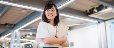 Young Japanese professional holding a notebook in a modern office